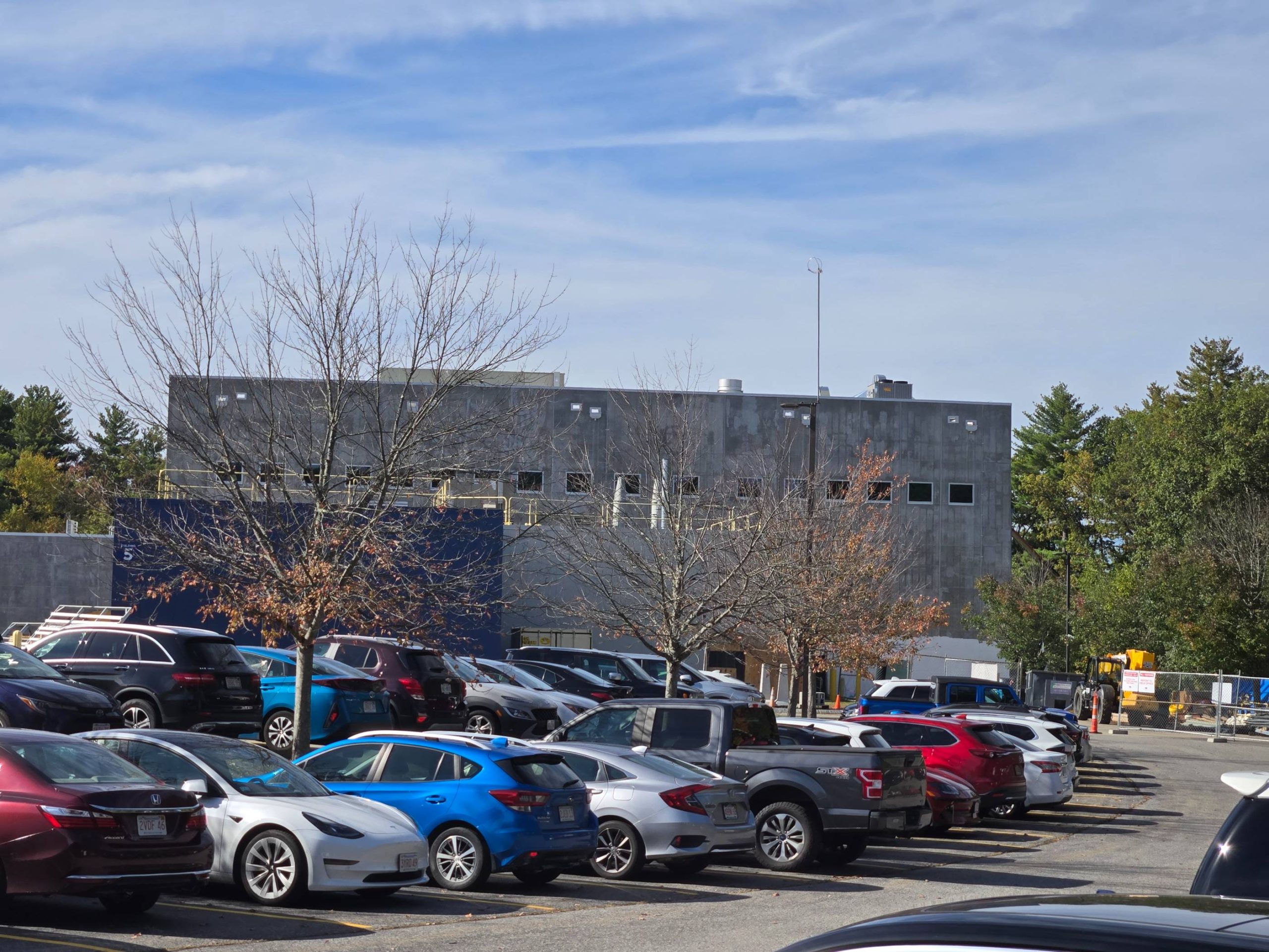 Building under construction sits behind parked cars.