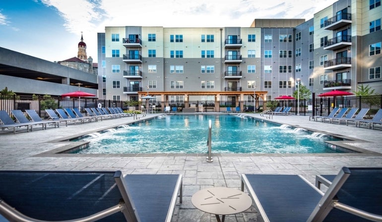 A pool with apartments behind it