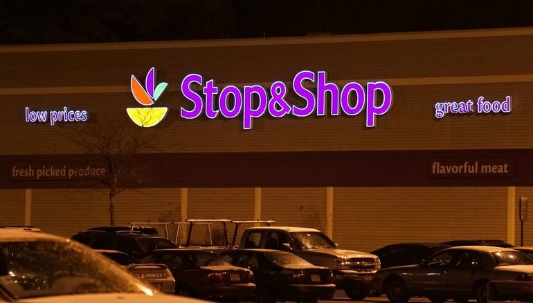 The exterior of a Stop & Shop supermarket at night with lit-up sign.
