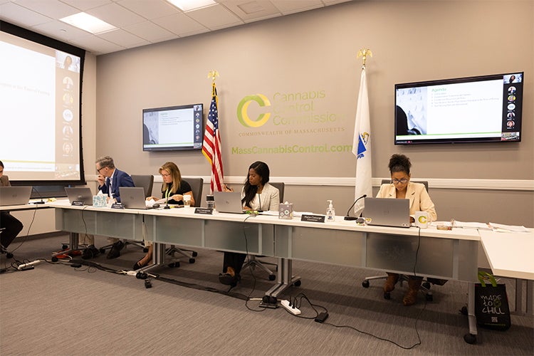 Four people sit at a table during a meeting