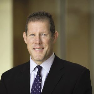 a man in a black suit with a tie