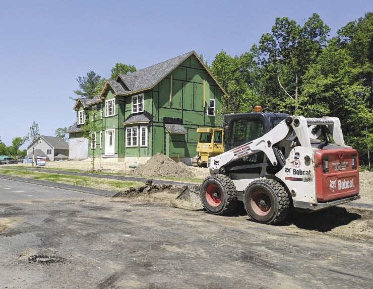A home under construction with a piece of construction equipment