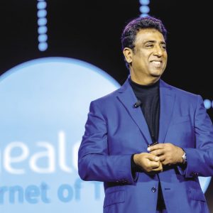 A photo of Girish Navani giving an on-stage presentation