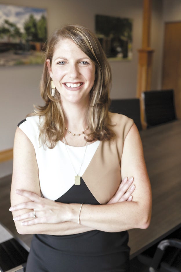 A woman with her arms crossed, smiling