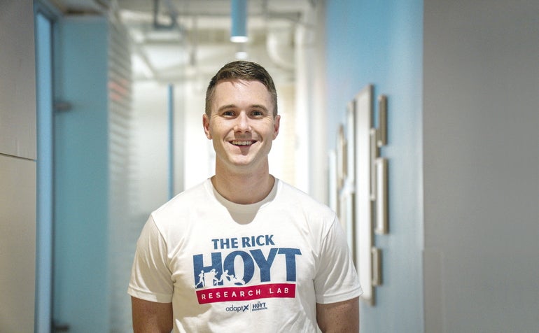 A young man wears a white T-Shirt that says 