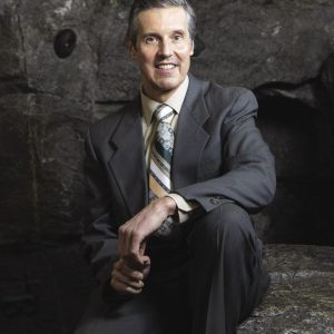 Victor Champagne sits in front of a dark backdrop.