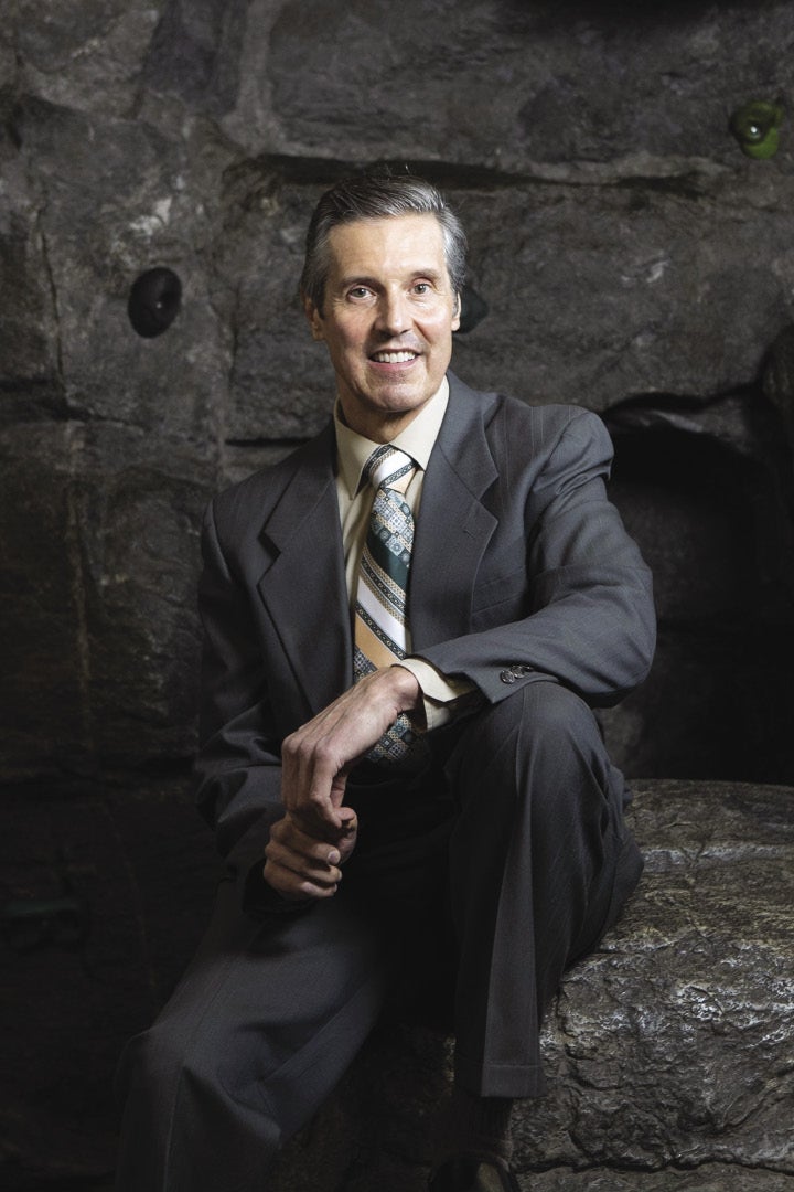 Victor Champagne sits in front of a dark backdrop.
