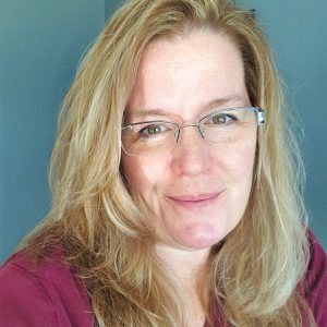 A headshot photo of a woman with glasses