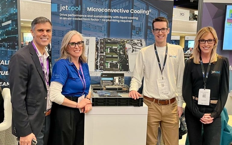 Four people smiling at a trade show