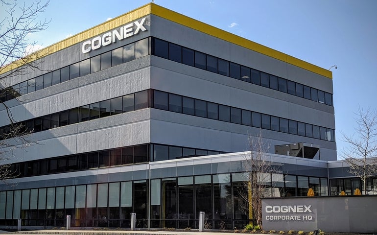 A grey building with yellow trim around the top and 