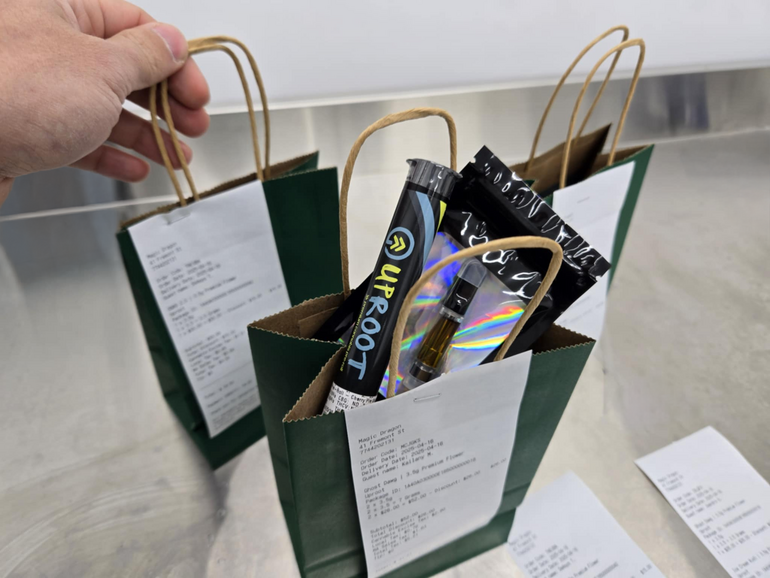 Three gift-sized bags of cannabis products, with receipts stapled to the bags.