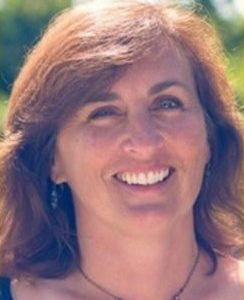 A woman with shoulder-length brown hair smiles for the camera.