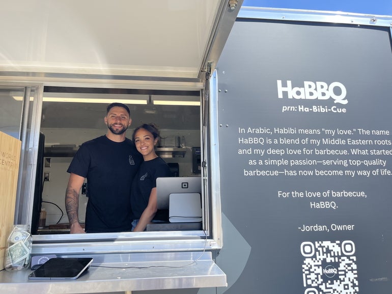 A man and a woman stand in a food truck.