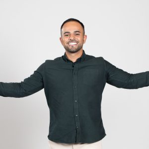 A man in a blue shirt outstretches his arms