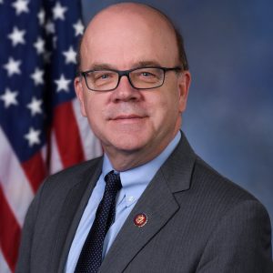 Man in suit in front of American flag
