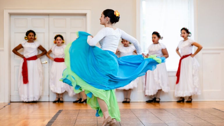A dancer in a blue dress dances