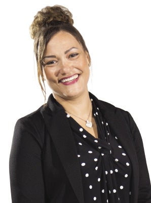 A woman in a black jacket and polka dot shirt