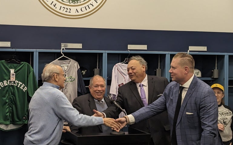Four men shake hands