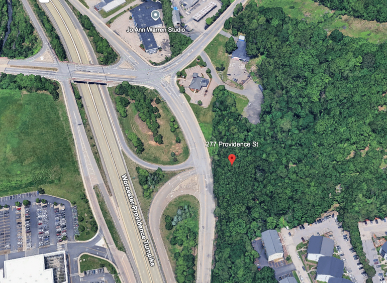 A satellite image of wooded land next to a highway