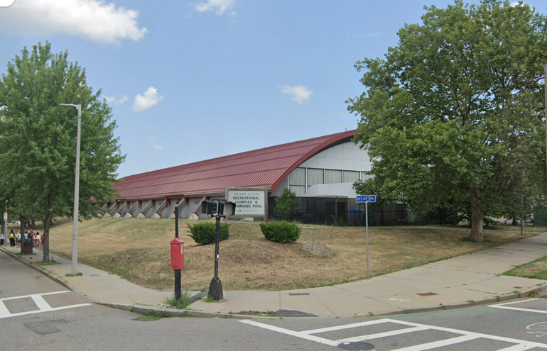 A large building sits behind a sign