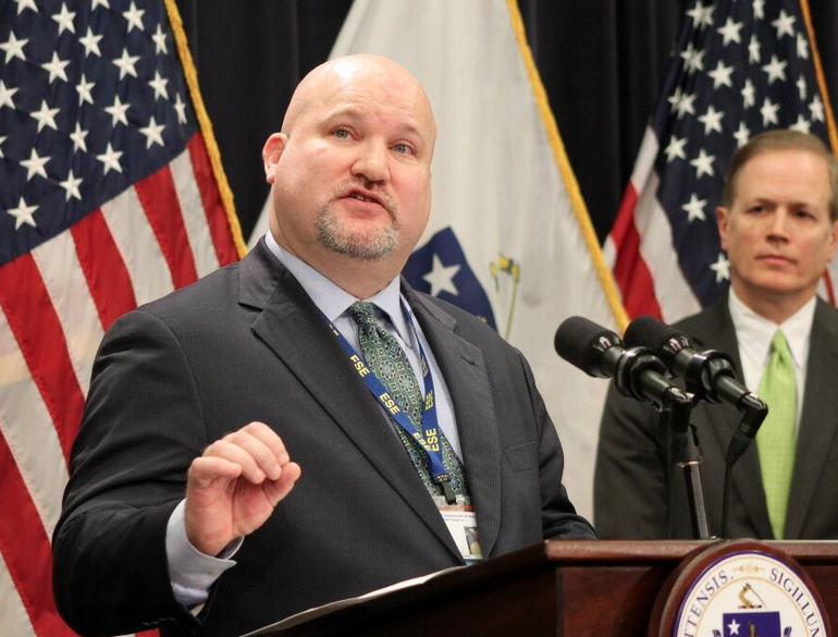 A man in a suit stands at a podium