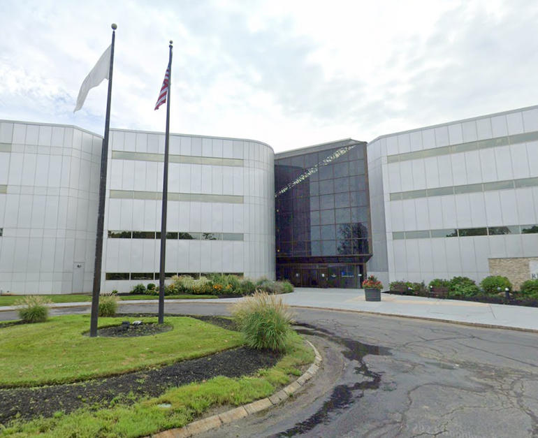A large office building with a traffic circle in front.