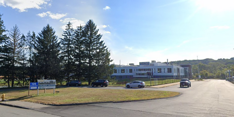 A large industrial campus with trees in front