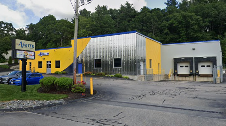 A yellow industrial building with a two-door loading dock