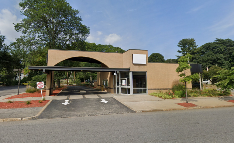 A small bank building with an drive-up teller
