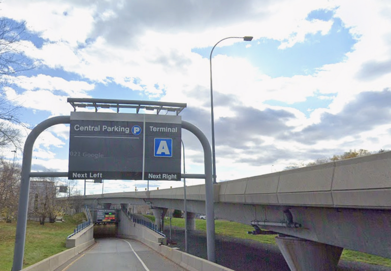 A sign for parking at Logan Aiport hanging over a road
