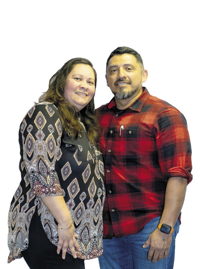 A woman and man stand next to each other smiling