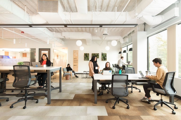 Workers sitting around desks working at a Workbar location in Woburn, Massachusetts.