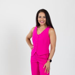 A woman wears a pink dress with a pink watch.