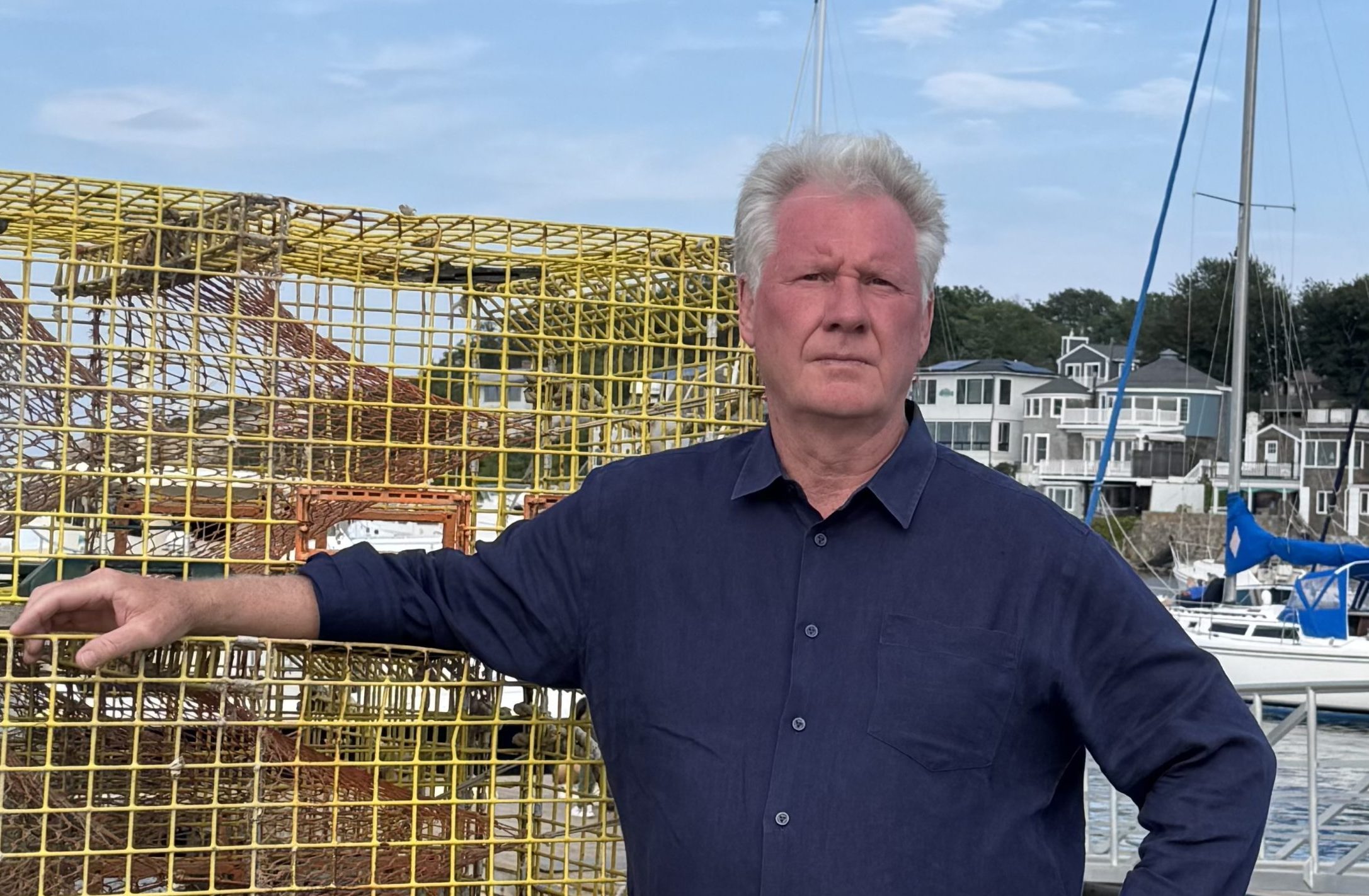 A man leans against lobster traps