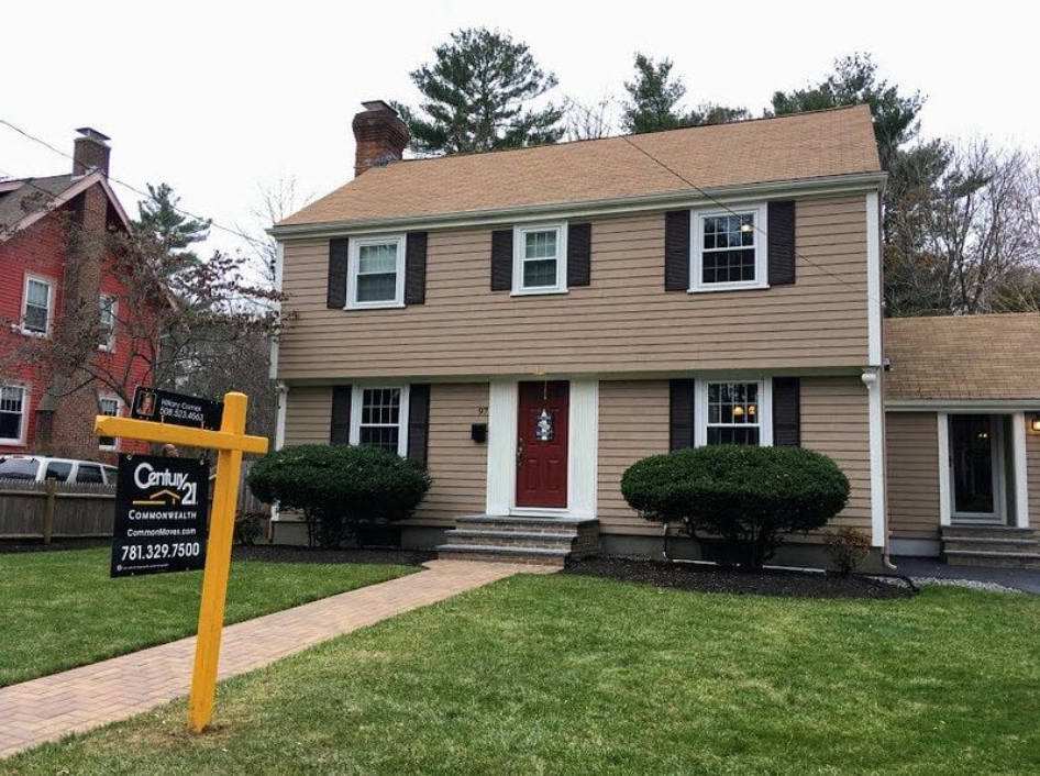 Two-story house with a for sale sign in front