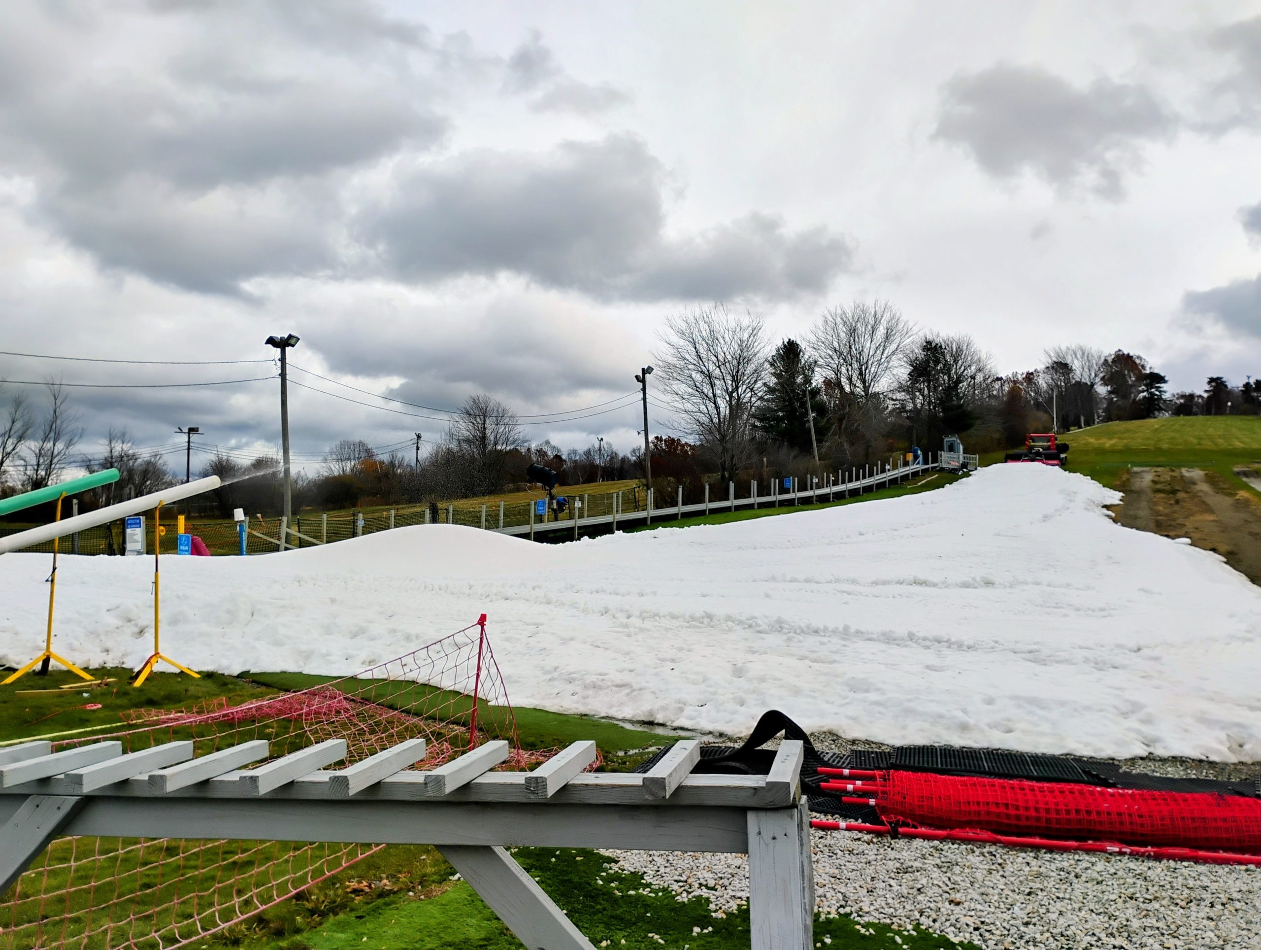 A small ski area with parts of the hill covered in snow