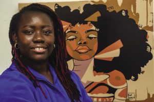 A woman with long braids wears a blue dress.