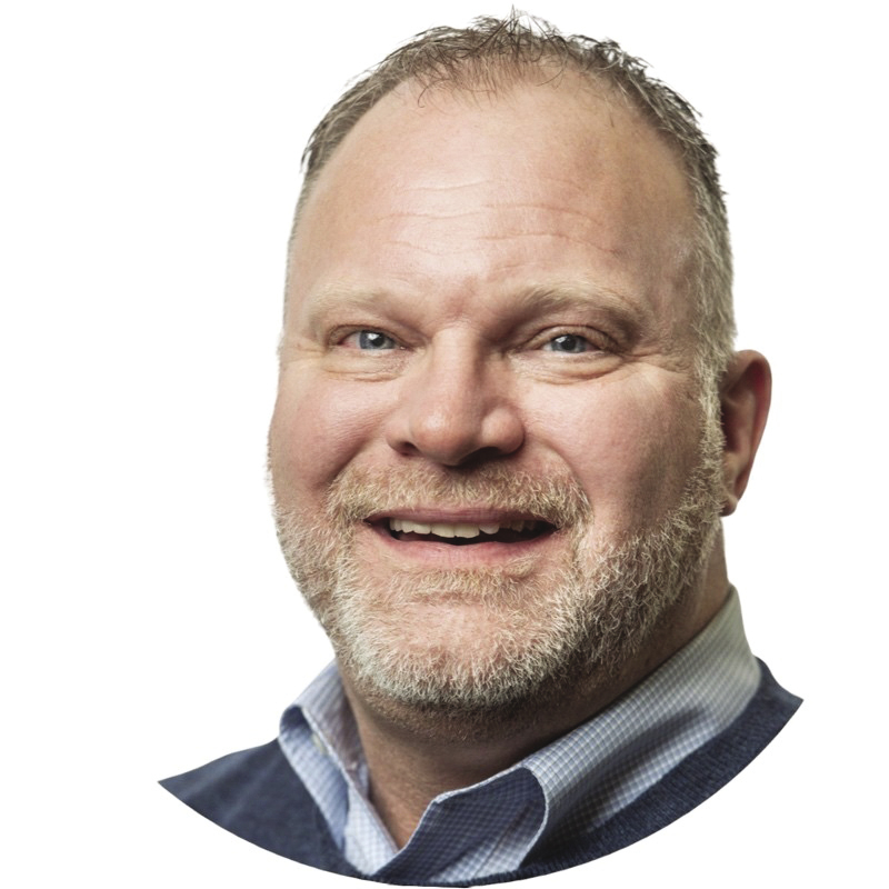 A headshot of a man wearing a blue button down.