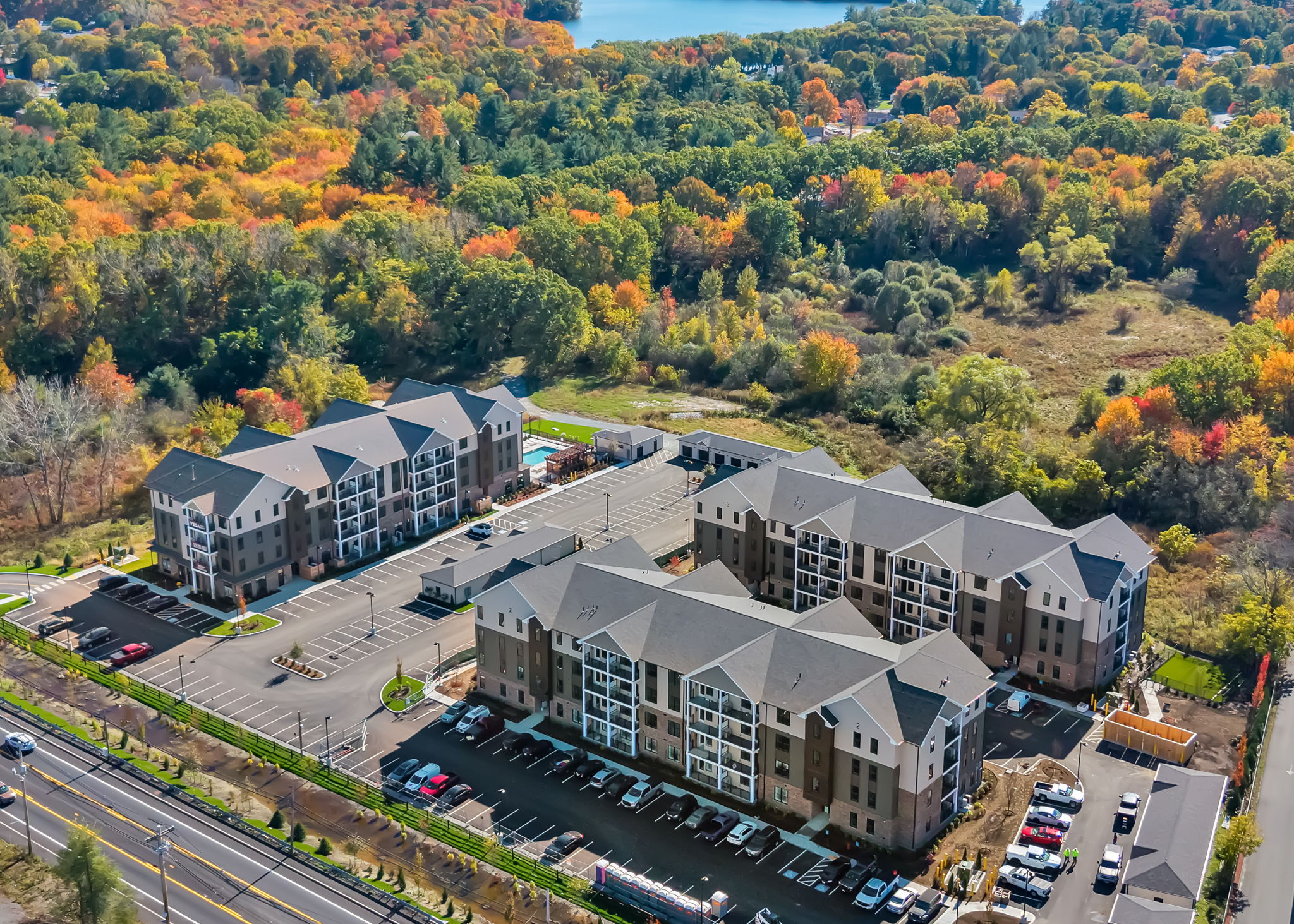 Aerial view of a three-building apartment complex in a wooded area
