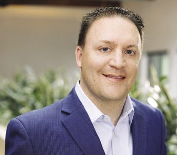 Man in suit smiles for photo