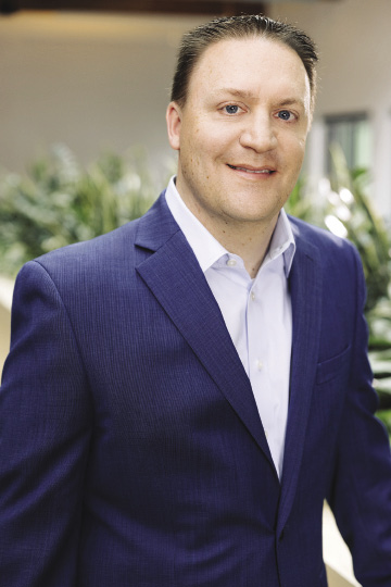 Man in suit smiles for photo