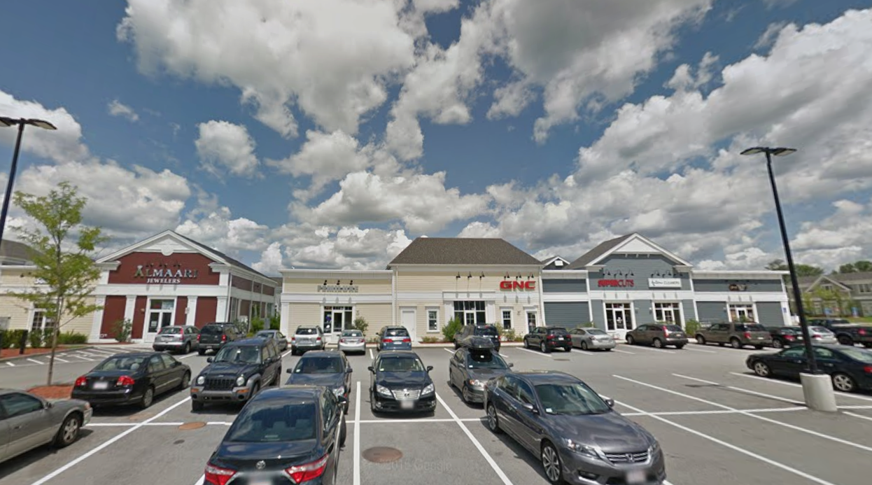 A retail plaza behind a parking lot