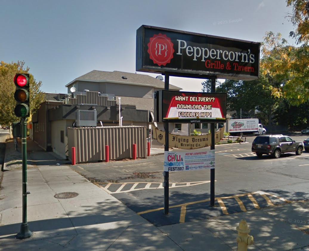 A two-story restaurant building sits behind a sign which reads 'Peppercorn's'