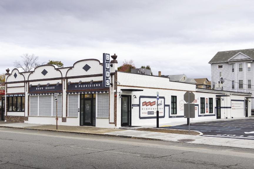 Outside a brick white building with black accents along a street
