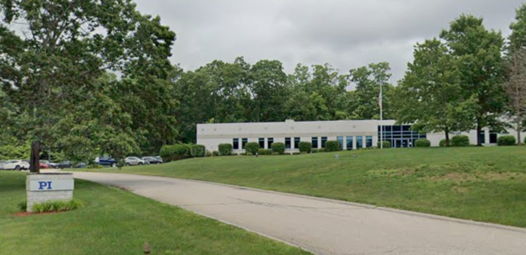A one-floor office building sits behind a grassy lawn