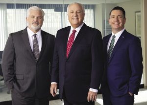 Three men in suits stand side by side.