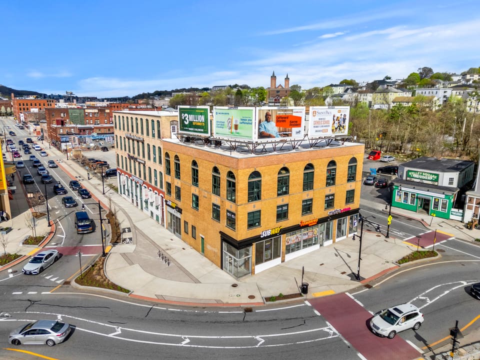 Aerial photo of three-story mixed-use building in an urban environment.